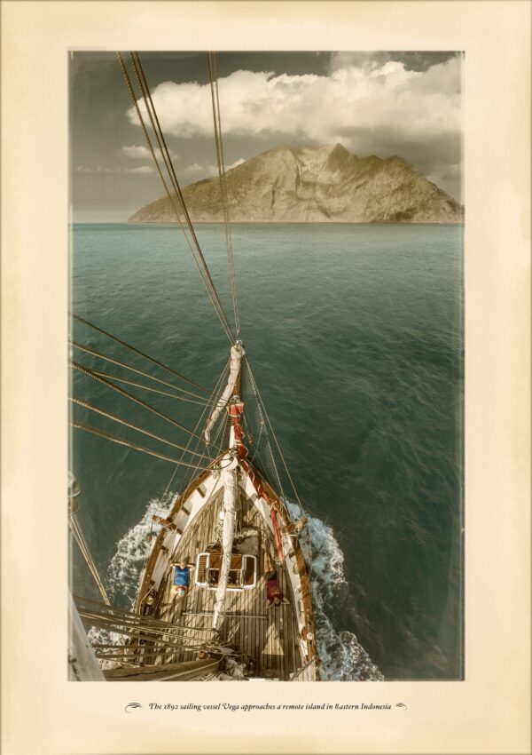 The historic sailing vessel Vega approaching the uninhabited volcanic island of Komba, Indonesia.